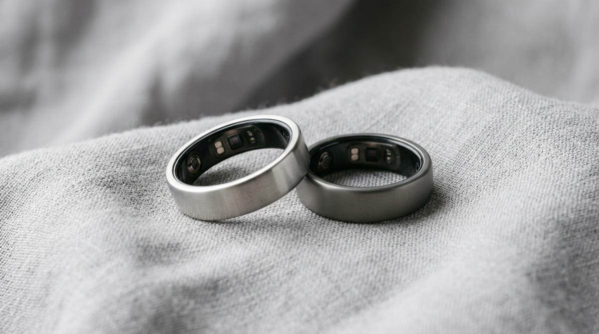 Two lightweight smart rings resting on grey fabric